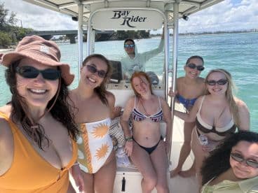 A joyful group of friends poses for a selfie aboard a Bay Rider boat, enjoying a sunny day on the water — perfect for fun outings and memorable adventures.