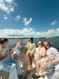 A joyful group of friends enjoys a sunny day on the water, capturing laughter and camaraderie aboard their boat — perfect for memorable outings and adventures.