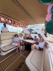 A lively group celebrates aboard a luxurious yacht, enjoying a festive atmosphere with decorations and camaraderie — perfect for special occasions on the water.