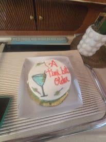 A beautifully decorated cake celebrating a special occasion, featuring a cocktail design, perfect for onboard festivities.