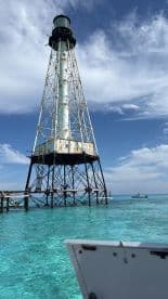 A stunning view of a lighthouse standing tall over crystal-clear waters, perfect for capturing the essence of coastal adventures and scenic boat trips.
