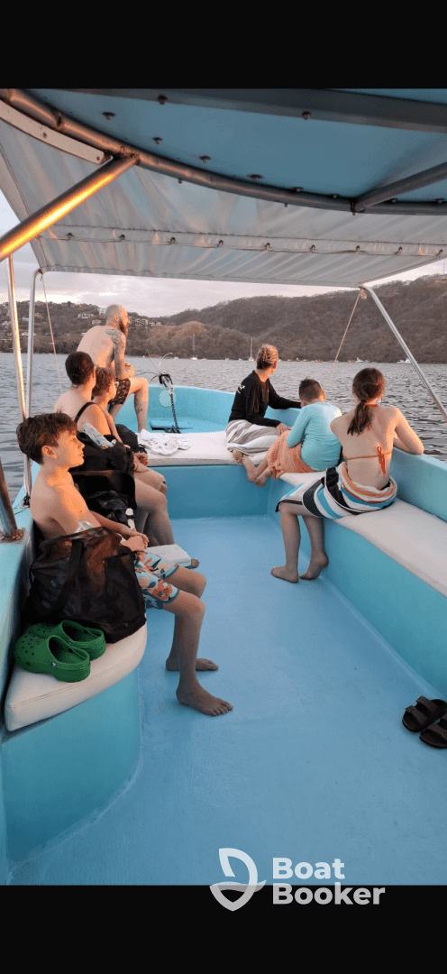 A group of friends and family relax on a boat, enjoying the scenic views at sunset — perfect for memorable outings on the water.