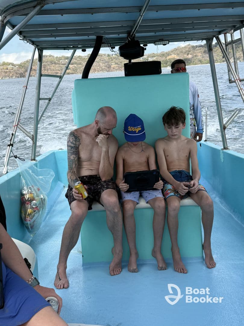 A family enjoys a relaxing moment aboard a boat, with kids engaged in entertainment while soaking up the sun — perfect for family outings on the water.