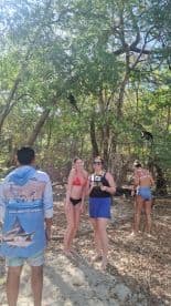 A group of friends enjoys a close encounter with monkeys in a lush natural setting, capturing a memorable wildlife experience.