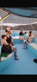 A group of friends and family relax on a boat, enjoying the scenic views at sunset — perfect for memorable outings on the water.
