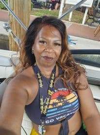 A woman enjoys her time on a boat, showcasing a vibrant vacation spirit. Perfect for capturing memorable moments on the water.