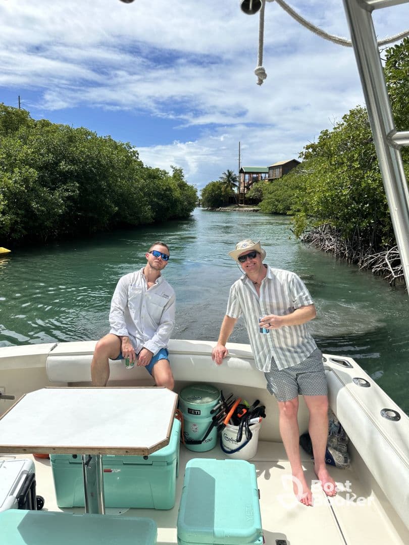 Two friends enjoy a sunny day on the boat, surrounded by lush mangroves and equipped with snorkeling gear — perfect for a fun day of exploration and adventure.