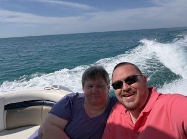 A couple enjoys a sunny day on the water, capturing a joyful selfie while boating in the ocean — perfect for memorable outings and adventures.