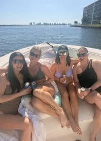 A group of friends enjoys a sunny day on the boat, sipping drinks and soaking up the sun — perfect for a fun day out on the water.