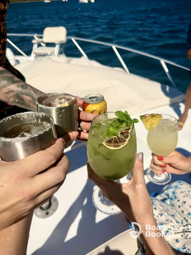 A lively group raises their cocktails in a toast aboard a boat, capturing the essence of celebration and fun on the water.