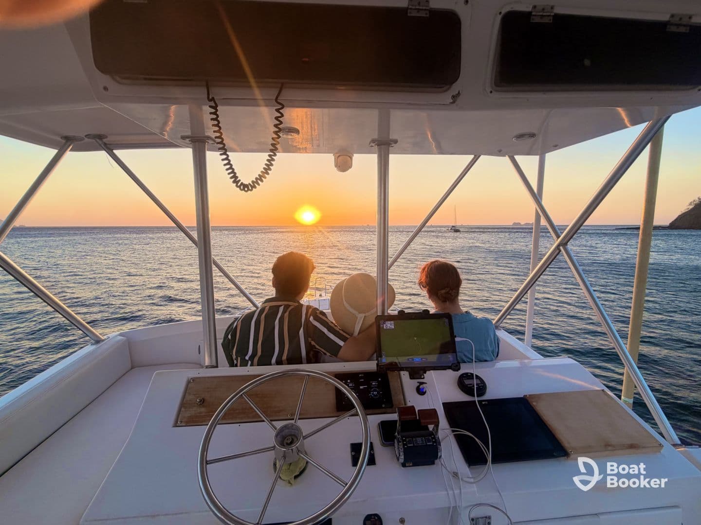 A couple enjoys a breathtaking sunset view from the helm of a boat, creating a perfect romantic atmosphere on the water.