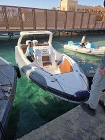 A sleek speedboat named 'Sunghida' docked at a marina, showcasing its stylish design and clear turquoise waters — perfect for a day of adventure on the sea.