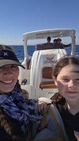 A joyful family captures a selfie on a boat tour, enjoying the beautiful ocean views — perfect for creating lasting memories on the water.
