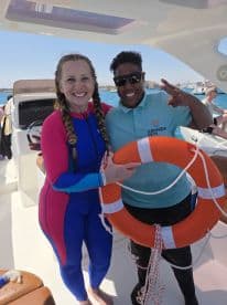 Two smiling individuals pose together on a boat, showcasing a fun moment during a boat tour — perfect for adventure seekers and group outings.