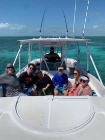 A lively group enjoys a day on the water aboard a boat, sharing drinks and laughter under the sun — perfect for a fun-filled outing with friends.