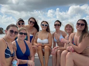 A joyful group of friends enjoys a fun day on the boat, showcasing their vibrant personalities and summer vibes — perfect for celebrations and memorable outings.