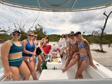 A lively group of friends enjoys a fun day on the boat, showcasing snacks and beach vibes — perfect for a memorable outing under the sun.