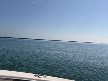 A distant view of calm waters under a clear sky, with no identifiable subjects or activities.