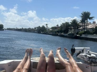 A group of friends relaxes on the deck of a boat, enjoying the scenic waterway views — perfect for a day of leisure on the water.
