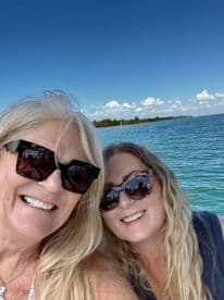 Two friends enjoy a sunny day on the water, capturing a joyful selfie while boating — perfect for memorable outings and adventures.