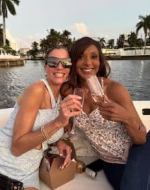 Two friends celebrate with cocktails on a boat, enjoying a beautiful sunset — perfect for memorable outings and gatherings on the water.