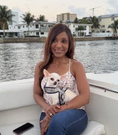 A woman enjoys a serene moment on a boat with her Chihuahua, showcasing the joy of pet-friendly boating experiences.
