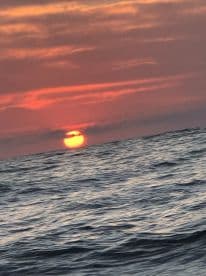 A blurry image of a sunset over the ocean, creating a serene but unclear view.