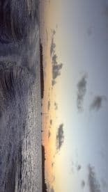 A stunning sunset over the coastline, showcasing the tranquil beauty of the water and sky — perfect for capturing memorable moments on a boat trip.