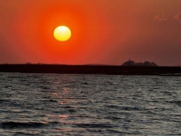 A stunning sunset over tranquil waters, perfect for capturing the beauty of evening boat rides.
