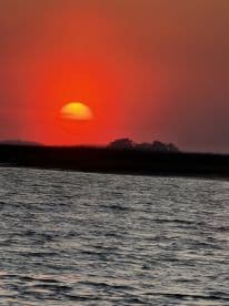 A stunning sunset over calm waters, creating a picturesque backdrop perfect for evening boat cruises.