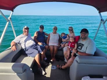 A joyful family enjoys a day out on a pontoon boat, creating lasting memories on the water with their little ones.