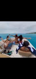 A lively group enjoys a fun moment on a boat, embracing the ocean breeze and celebrating together — perfect for memorable outings on the water.