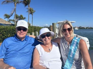 A joyful birthday celebration with family on a boat, showcasing smiles and togetherness against a beautiful waterfront backdrop.