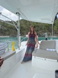 A woman poses inside a stylish boat cabin, showcasing the comfortable seating and inviting atmosphere — perfect for relaxing on the water.