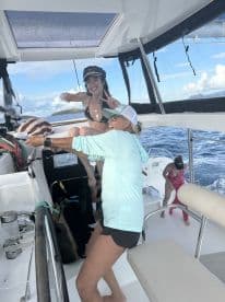 A lively moment aboard a boat as two women share a fun interaction, showcasing the joy of a day on the water with friends.