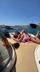 Two friends enjoy a sunny day on the deck of a boat, perfect for relaxation and bonding on the water.