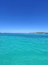 A scenic view of turquoise waters under a clear blue sky, showcasing the beauty of a tropical destination.
