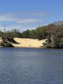 A scenic view of a sandy area along the water, but the image lacks clarity and detail.
