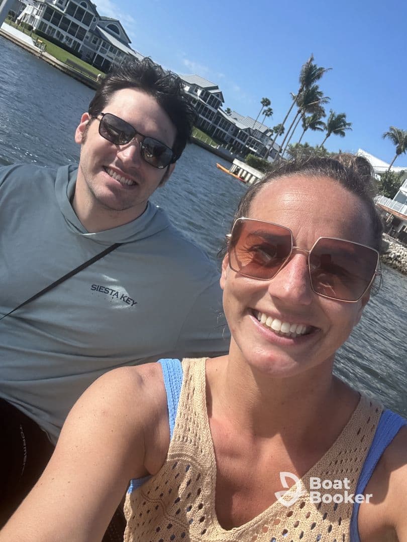 A cheerful couple takes a selfie while enjoying a sunny day on the water in Siesta Key, perfect for capturing memorable moments during their boating adventure.