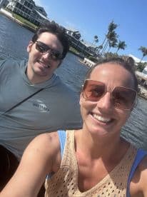 A cheerful couple takes a selfie while enjoying a sunny day on the water in Siesta Key, perfect for capturing memorable moments during their boating adventure.