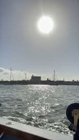 A picturesque view of a harbor with sparkling water under the sun, showcasing the beauty of a boating experience.