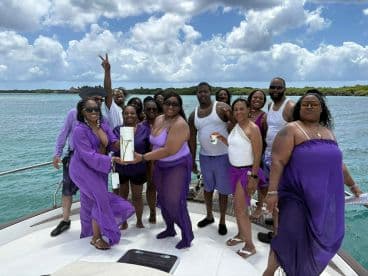 A lively group of friends celebrates together on a boat, showcasing joy and camaraderie against a beautiful water backdrop — perfect for memorable gatherings and parties.