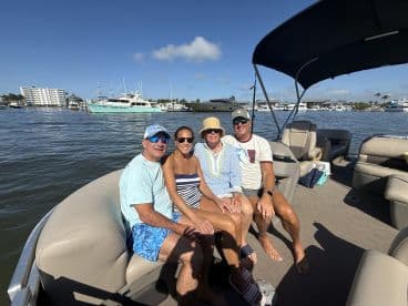 A cheerful group enjoys a sunny day on a pontoon boat, perfect for creating lasting memories on the water.