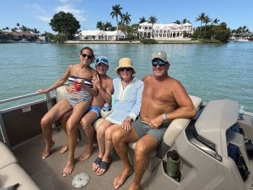 A cheerful group enjoys a sunny day on a pontoon boat, showcasing the perfect setting for fun and relaxation on the water.