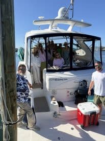 A lively group poses for a photo aboard a boat, capturing the essence of a fun-filled day on the water — perfect for celebrations and gatherings.