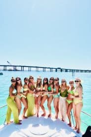 A vibrant group of friends celebrates on the deck of a boat, enjoying a sunny day on the water — perfect for summer parties and memorable outings.