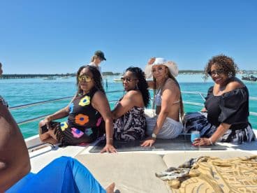 A joyful group of women enjoying a sunny day on a boat, perfect for celebrations and memorable outings on the water.