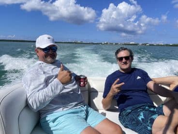 Two friends enjoy a fun day on the water, showcasing the joy of boating and camaraderie under a sunny sky.