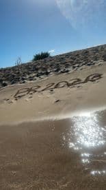 An unclear image featuring sand with markings, possibly a message or design, but lacks identifiable context.