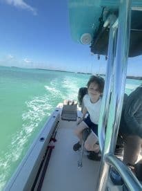 A child enjoys a boat ride on turquoise waters, capturing the joy of family adventures on the water.